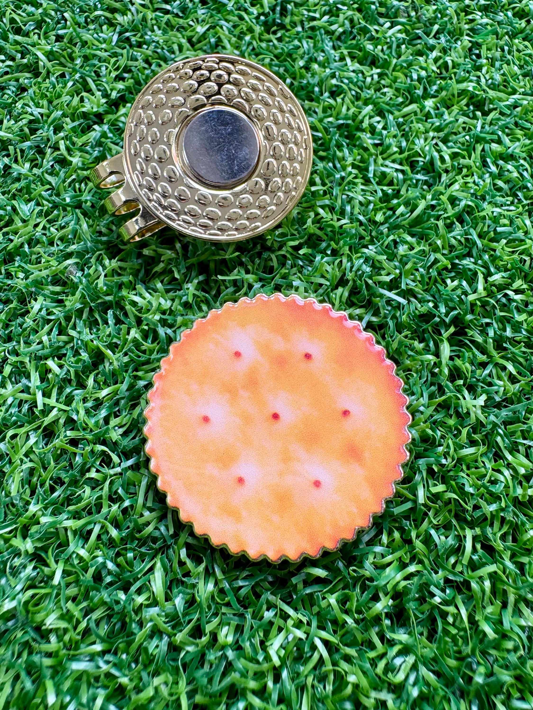 Unique cracker/biscuit golf ball marker with magnetic hat clip